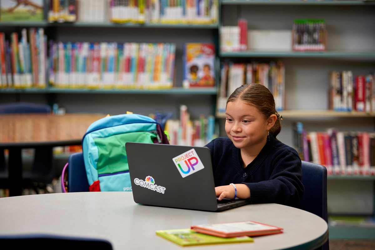 Student using a laptop with Comcast branding.